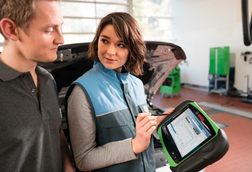 Bilmekaniker använder Bosch-verktyg för arbete och bilinspektion  i verkstad