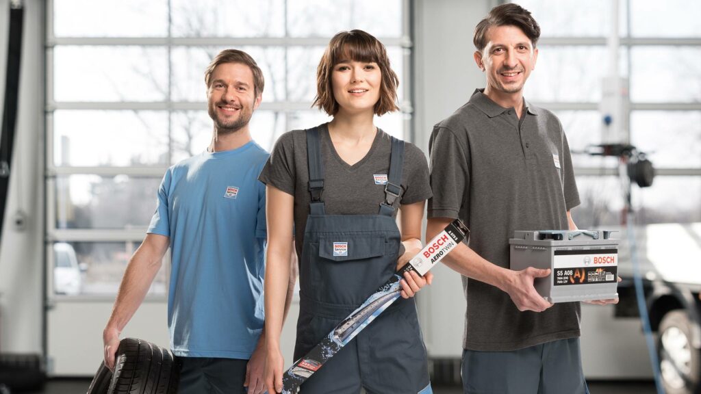 Personal med originaldelar som bilbatteri, torkarblad och däck från Bosch