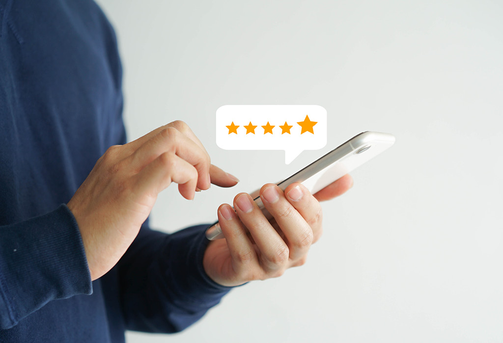 Hand håller mobil med femstjärnigt betyg – kundrecensioner online